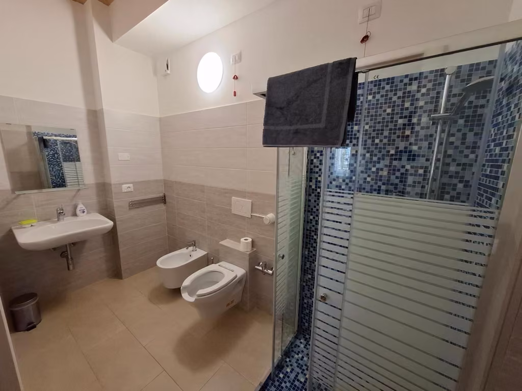 Bagno con lavandino e doccia di una camera della Country House Andromeda